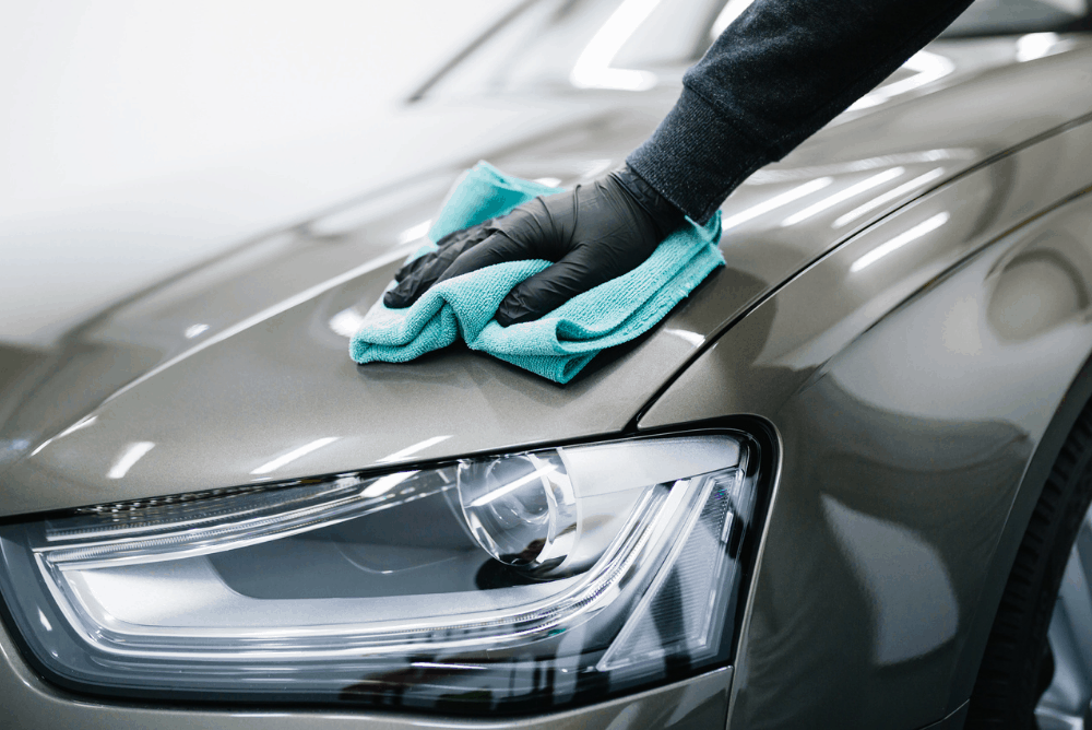 Vehicle being wiped clean with microfibre cloth